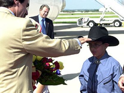 Aznar saluda a un niño con sombrero tejano a la llegada al aeropuerto de San Antonio (Texas).
