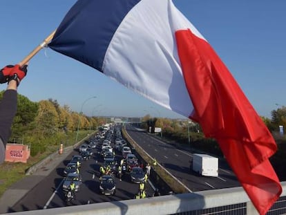 Un manifestante vestido con un chaleco amarillo ondea una bandera francesa en Toulouse, durante la jornada de movilización contra la subida de los impuestos de la gasolina