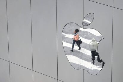 FILE PHOTO: FILE PHOTO: A woman is reflected in a Apple store logo in San Francisco