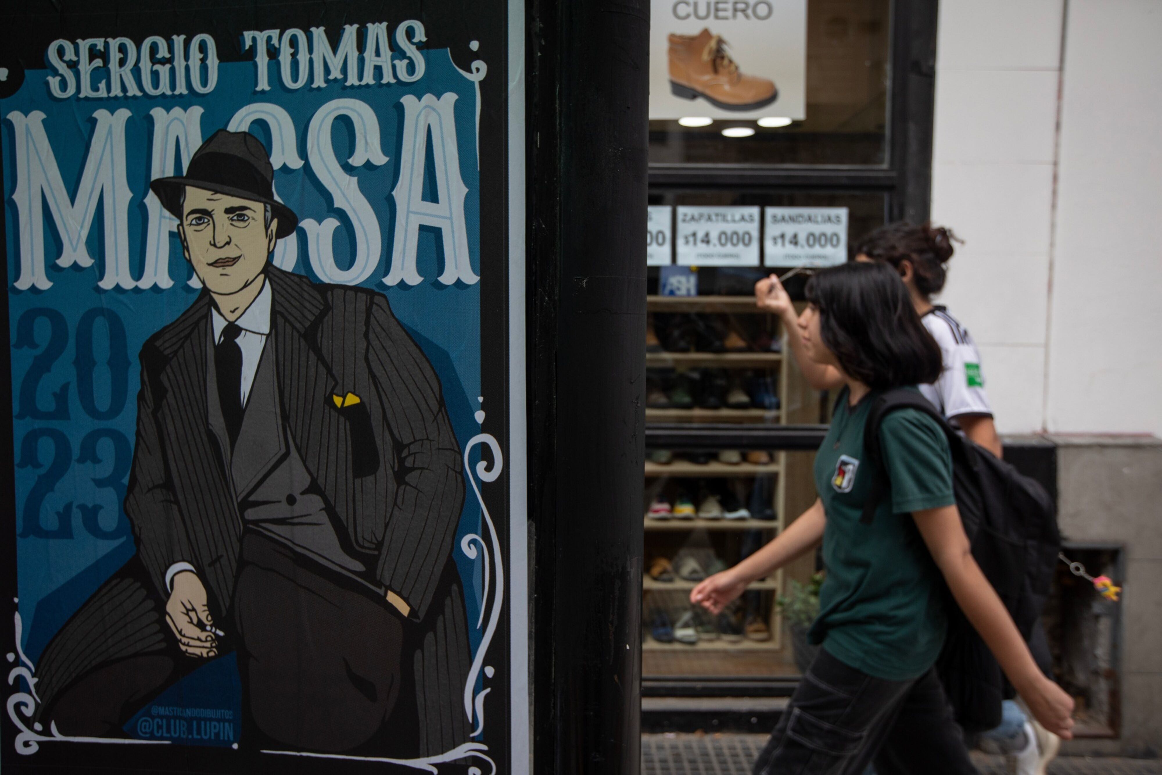 Transeúntes pasan frente a uno de los carteles de Sergio Massa en Buenos Aires. 