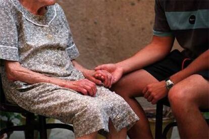 Un voluntario atiende a una anciana en su domicilio de Madrid.