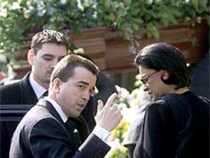 El hijo y la viuda del empresario fallecido, a su llegada al funeral, celebrado el jueves en París.