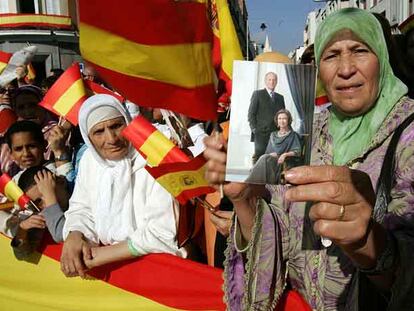Vecinos de Melilla exhiben fotografías de los Reyes y banderas durante la visita.