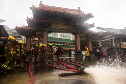 Fire-fighters drain out water following heavy rainstorms in Hong Kong, Friday, Sept. 8, 2023