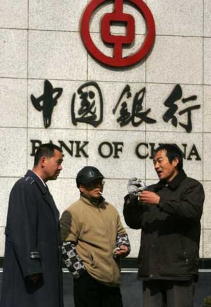 Ciudadanos frente a una sucursal del Banco de China en Shanghai.