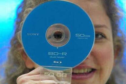 Una mujer muestra un disco Blu-Ray de 50 gigabytes de capacidad en la feria tecnológica CeBIT de Hannover, en marzo de 2005.