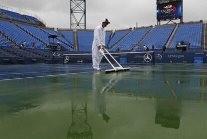 Un operario intenta despejar de agua la pista central neoyorquina.