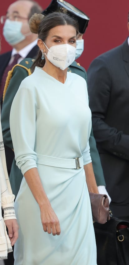 En el desfile de este martes, la reina Letizia ha estrenado un vestido midi color azul celeste de manga larga y drapeado en uno de los laterales, de la diseñadora María Barragán.