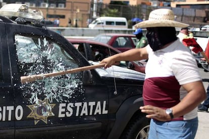 Homem quebra o vidro de um carro policial em Chilpancingo.