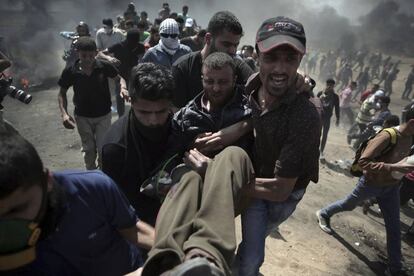 Un herido es trasladado por manifestantes durante la protesta entre la frontera de Gaza con Israel, el 14 de mayo de 2018.