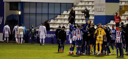 Los jugadores del Alcoyano celebran la clasificación, con los jugadores del Madrid al fondo abandonando el césped de El Collao. / (EFE)