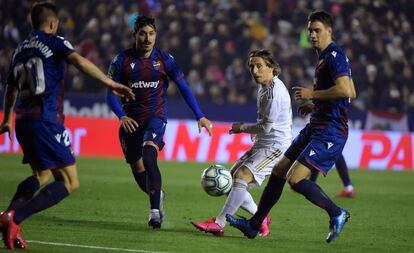 Modric da un pase entre varios jugadores del Levante.