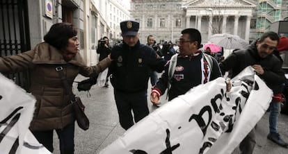 Un polic&iacute;a desaloja a activistas antidesahucios de los aleda&ntilde;os del Congreso