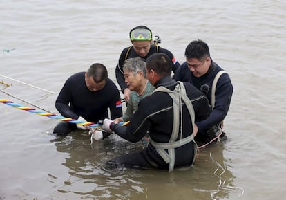 Diversos membres dels equips de rescat ajuden a sortir de l'aigua un passatger del vaixell sinistrat.