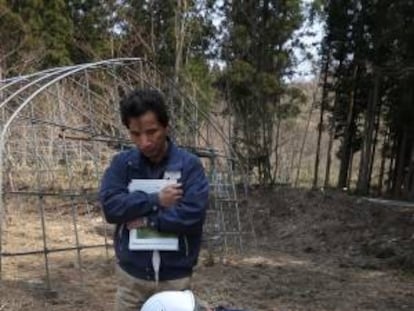 Yasushige Watanabe, un agricultor que se niega a regresar a su casa, en Miyakoji, observa cómo un técnico mide el nivel de radiación en un campo junto a su vivienda.