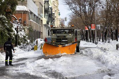 Miembros de la a Unidad Militar de Emergencias (UME) ayudados de una máquina quitanieves trabajan retirando la gran nevada en el paseo de la Castellana en Madrid, este domingo.