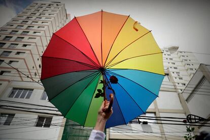 Manifestante defende bandeira LGBT, em frente a um colégio eleitoral de São Paulo