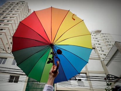 Manifestante defende bandeira LGBT, em frente a um colégio eleitoral de São Paulo