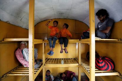 Siddharth Dhage, de 10 años, y su vecino Gaurav Ganesh, de 13 años, se sientan en el maletero de un tren en su viaje de regreso a la estación de tren de Mukundwadi, en Aurangabad.