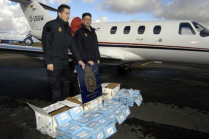 Dos agentes de la Policía Nacional muestran la droga incautada, más de 106 kilogramos de cocaína, junto al aparato utilizado para su transporte desde Guinea-Bissau.