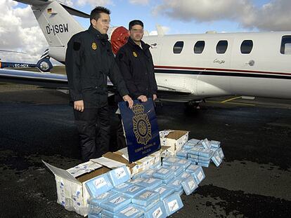 Dos agentes de la Policía Nacional muestran la droga incautada, más de 106 kilogramos de cocaína, junto al aparato utilizado para su transporte desde Guinea-Bissau.