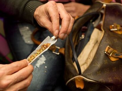 Un socio de la asociaci&oacute;n cann&aacute;bica barcelonesa l&iacute;a un porro.