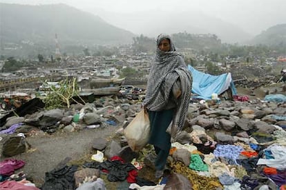 Una víctima del terremoto busca plásticos con los que construir un refugio para sus hijos en Balakot.