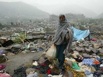 Una víctima del terremoto busca plásticos con los que construir un refugio para sus hijos en Balakot.