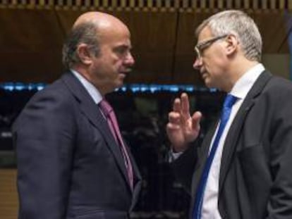 El ministro español de Economía y Competitividad, Luis de Guindos (i), conversa con el ministro de Finanzas lituano, Rimantas Sadzius, antes del comienzo de la reunión de los ministros de Economía de la UE celebrada hoy en Luxemburgo.