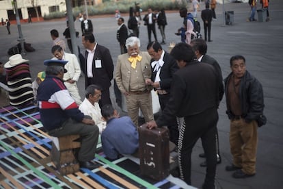 Los mariachis pasan el tiempo jugando a las cartas mientras esperan clientes para su música