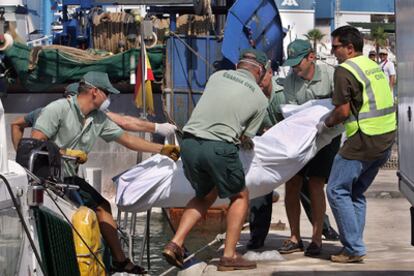 El cadáver del inmigrante rescatado ayer en alta mar, en el momento de ser trasladado a tierra en Santa Pola.