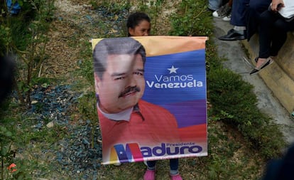 Criança segura banner em apoio a Maduro.