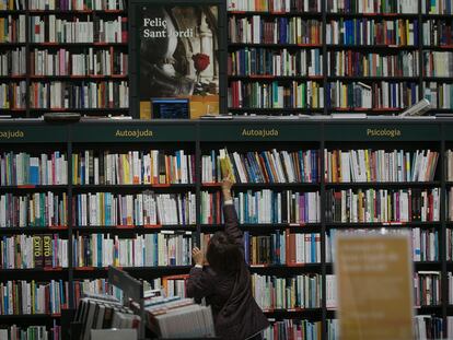 Un cliente coge un ejemplar en una librería barcelonesa dos días de la jornada de Sant Jordi.