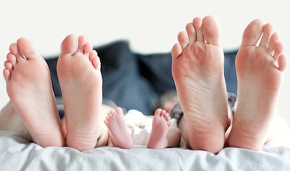 Feet of family in bed.