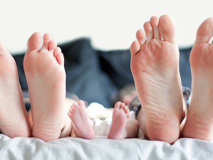 Feet of family in bed.