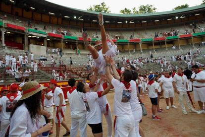 Uno chicos mantean a una joven en la plaza de toros de Pamplona tras el encierro, el 8 de julio de 2016.