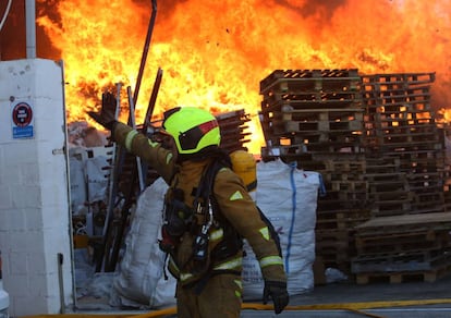 Un bombero en el incendio que se ha declarado en un almacén de Elche.