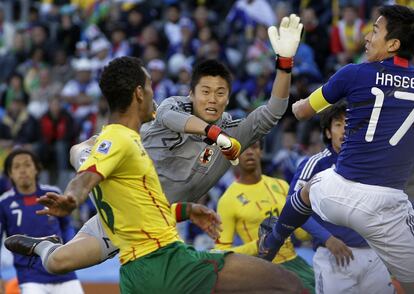 El portero de Japón, Eiji Kawashima, salta para bloquear un balón en el área.