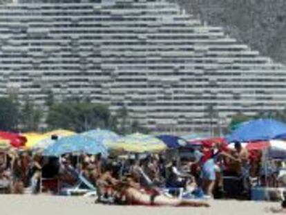 Veraneantes disfrutan al pie de los apartamentos de la playa de Cullera, en Valencia.