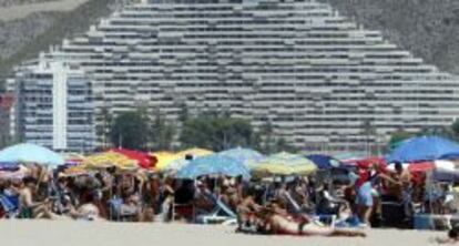 Veraneantes disfrutan al pie de los apartamentos de la playa de Cullera, en Valencia.