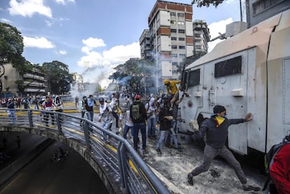Manifestantes protestando contra el gobierno del presidente Nicolas Maduro atacan un vehículo de cañones de agua durante los enfrentamientos con la policía antidisturbios en Caracas el 8 de abril de 2017.
