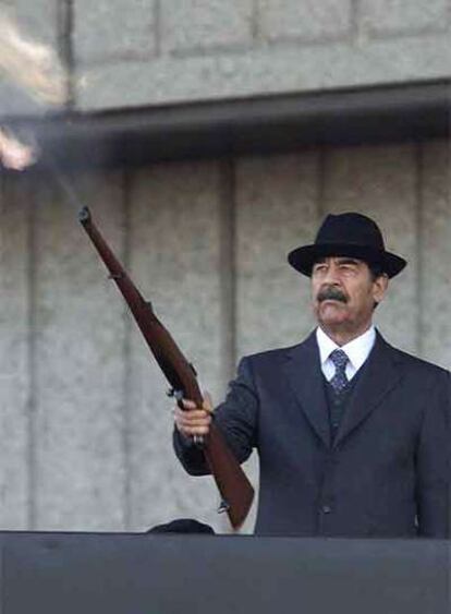 Sadam Husein dispara un fusil al aire durante un desfile militar en 2000.