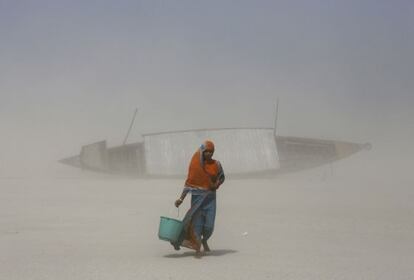 Una mujer india carga con agua cerca del río Brahmaputra, en Gauhati (India).