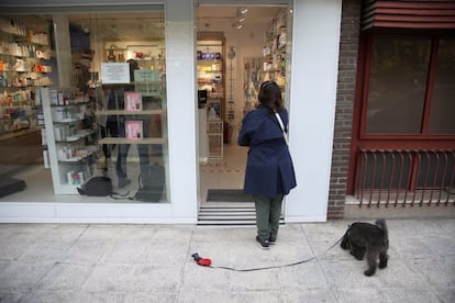 A client waits outside a pharmacy in downtown Madrid.