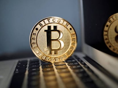 El logo de bitcoin, sobre el teclado de un ordenador.