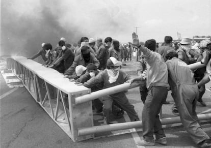 Trabajadores de Astilleros Españoles colocan una barricada durante el corte de carretera que efectuaron como protesta contra la reducción de las plantillas y el cierre de la factoría gaditana anunciado por la dirección de la empresa.