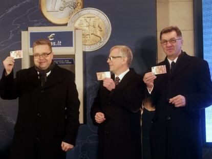 El presidente del Banco de Lituania Vitas Vasiliauskas (a la izquierda), el ministro de finanzas de Lituania Rimantas Sadzius (en el centro) y el primer ministro de Lituania Algirdas Butkevicius, tras retirar un billete de 10 euros de un cajero automático en Vilnius (Lituania) este 1 de enero.