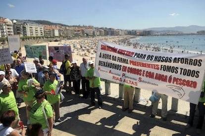 Los manifestantes afectados por las participaciones preferentes, ayer en la playa de Silgar de Sanxenxo.