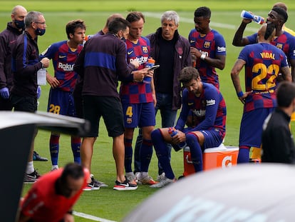 Quique Setién y su segundo entrenador, Eder Sarabia, dan indicaciones a sus jugadores durante el receso para hidratación.