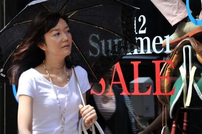 Una mujer pasea por una calle comercial de Tokio.